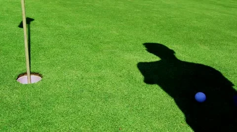 Golf - Shadow puts Ball in Hole from right hand side Stock Footage 11240021