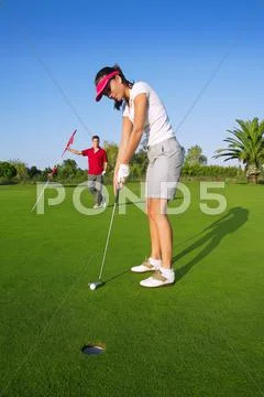 Golf woman player green putting hole golf ball Stock Photos