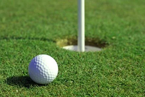 Golfball in front of the hole Stock Photos