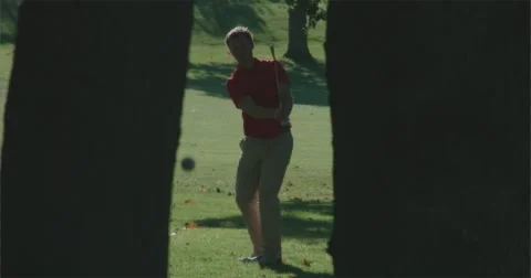 Golfer chips between to two trees. Vídeos de archivo 58850846