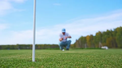 A Golfer Concentrating While Putting on the Green Under a Beautiful Clear Blue Stock Footage 346359729