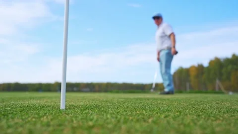 A Golfer Concentrating While Putting on the Green Under a Beautiful Clear Blue Stock Footage 346359807