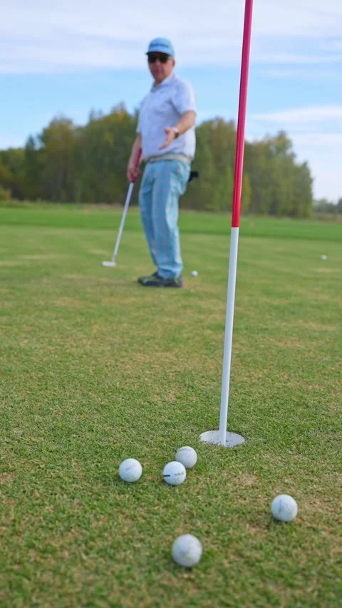 A Golfer Concentrating While Putting on the Green Under a Beautiful Clear Blue Stock Footage 346359948
