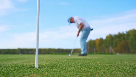 A Golfer Concentrating While Putting on the Green Under a Beautiful Clear Blue Stock Footage 346360358