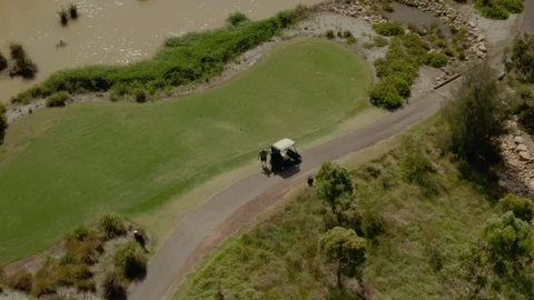 A golfer getting ready to tee off with his golf cart on the green. Stock Footage 98732322