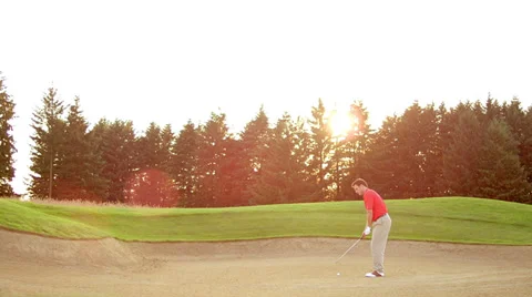 A golfer hits a nice shot out of a sand trap on a beautiful day on a golf course Stock Footage 33896394