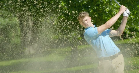A Golfer hits a shot out of a sand trap in slow motion. Vídeo Stock 112017289