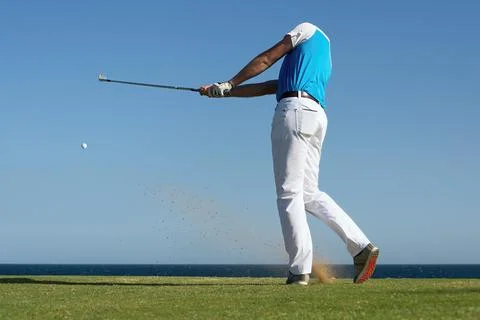 Golfer hitting ball with force Foto stock