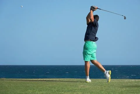 Golfer hitting ball with force Stock Photos