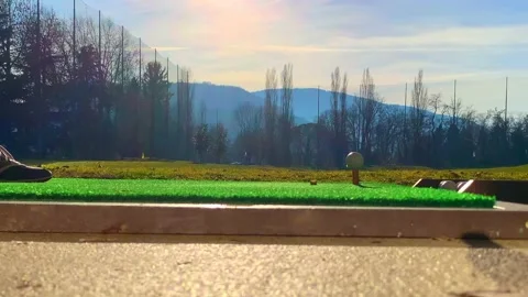 Golfer Hitting the Golf Ball with Driver on Mat in Driving Range Stock Footage 194011928