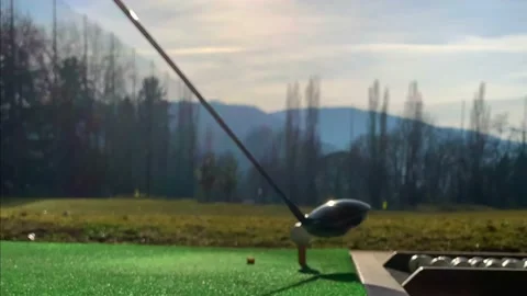 Golfer Hitting the Golf Ball with Driver on Mat in Driving Range with Sunlight Stockbeeldmateriaal 194011969
