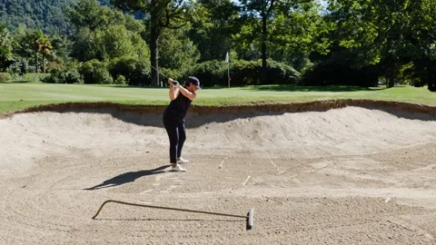 Golfer Hitting the Golf Ball From Sand Trap to Putting Green in a Sunny Day Stock Footage 211403317