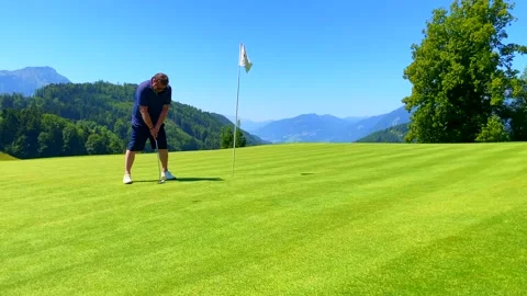 Golfer on Infinity Putting Green Putting the Golf Ball in the Hole with Mountain Stockbeeldmateriaal 202524022