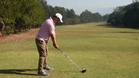 Golfer learns to kick the golf ball on the course Stock Footage 146466993