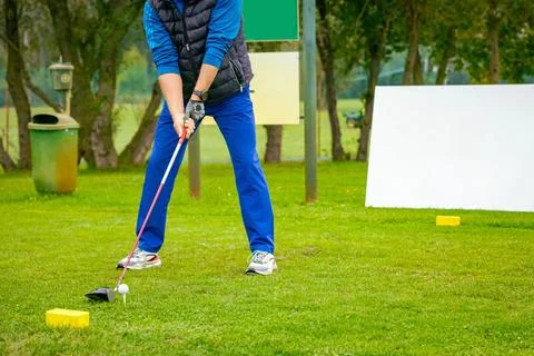 Golfer performs a strong golf shot to fairway Stock Photos