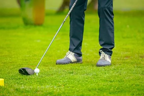 Golfer performs a strong golf shot to fairway Stock Photos