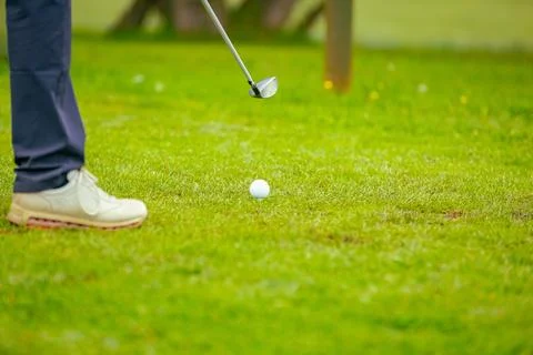 Golfer performs a strong golf shot to fairway Stock Photos