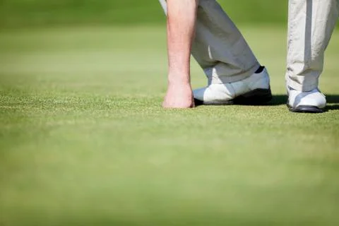 Golfer picking up ball. Stock Photos
