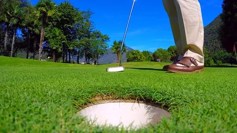 Golfer Picking Up the Golf Ball from the Golf Hole on the Golf Green Stockbeeldmateriaal 112120637