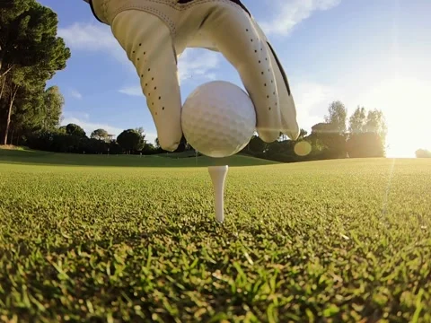 Golfer placing golf ball on the tee at golf course before shot Stock Footage 197393920