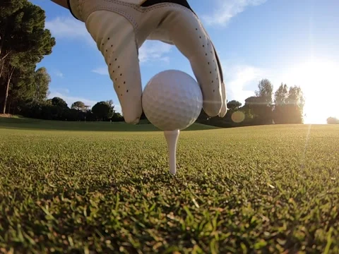 Golfer placing golf ball on the tee at golf course before shot Stock Footage 197393944