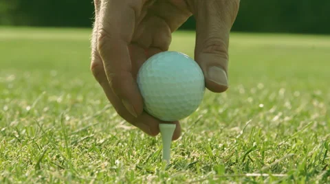 Golfer placing white golf ball onto tee - Slow Motion Stock Footage