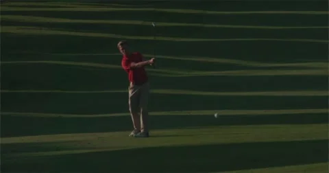 Golfer plays ball towards camera as low sun creates shadows. Vídeo Stock 58841370