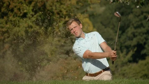 A golfer plays out of a sand trap and celebrates a great shot. Vídeo Stock 80418822
