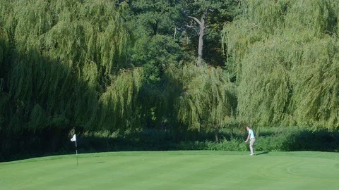 A Golfer plays a shot onto the green. Vídeo Stock 80420456
