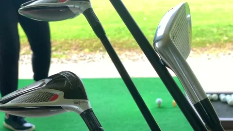 Golfer Practice Golf Swing with Her Driver in Driving Range and a Golf Bag Stock-Footage 161220683
