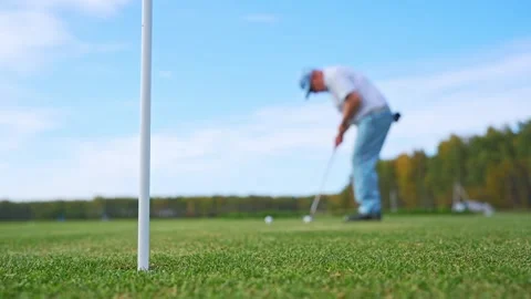 A golfer practices his putting skills on a sunny day, enjoying the greenery Stock Footage 346360112