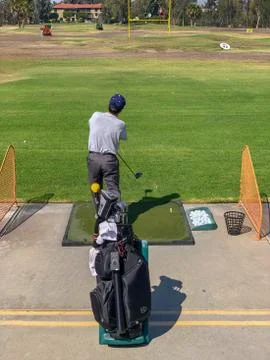 Golfer practicing at golf driving range practice facility Stock Photos