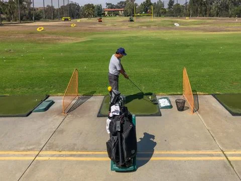 Golfer practicing at golf driving range practice facility Stock Photos