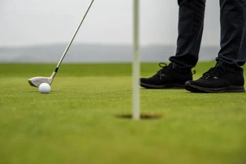 Golfer precision strike sends out ball into a hole Stock Photos