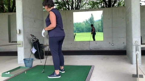 Golfer Preparation to Practicing Golf Swing in Driving Range Stock Footage 194011571