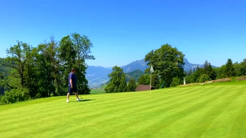 Golfer Putting the Golf Ball Close to the Hole with Mountain View Stock Footage 203526583