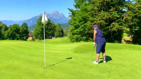 Golfer Putting the Golf Ball Close to the Hole with Mountain View and Sunlight Stock-Footage 203764624