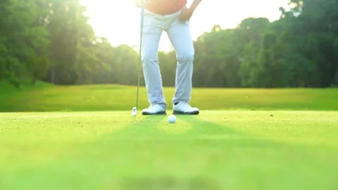 Golfer putting golf ball down hole to winner in beautiful golf course on bright  Stock Footage 91392458
