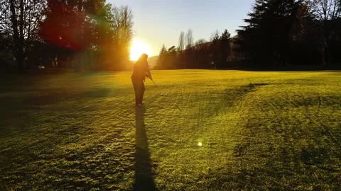 Golfer with Shadow Making Practice Golf Swing on the Fairway in Sunset Stock-Footage 267734379