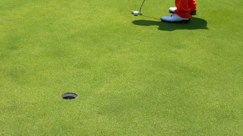 Golfer slow motion putting golf ball into hole on green golf course Stock Footage 106858320