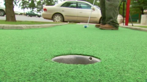 Golfer stroking golf ball into hole Stock Footage 54593358