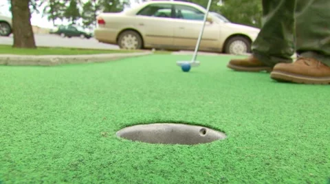 Golfer stroking golf ball into hole Stock Footage 54593363