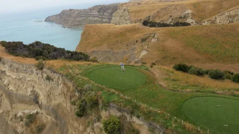 Golfer Swinging on Cliffside Golf Course (Drone) Stock Footage 86775797
