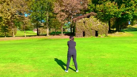 Golfer Taking a Shot on the Golf Course with an Old House with Plants 動画素材 165201337
