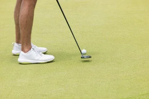 A golfer taking a shot on the green Fotos de archivo