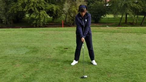 Golfer Teeing Off and Hitting with Her Driver the Golf Ball on Golf Course Stockbeeldmateriaal 219011487