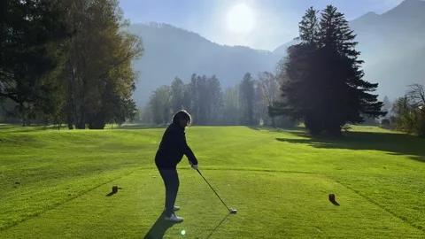 Golfer Teeing Off on a Beautiful Golf Course with Mountain View and Trees Stock Footage 292157221
