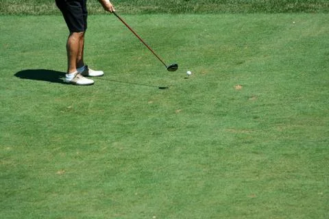 Golfer teeing off with a driver Stock Photos