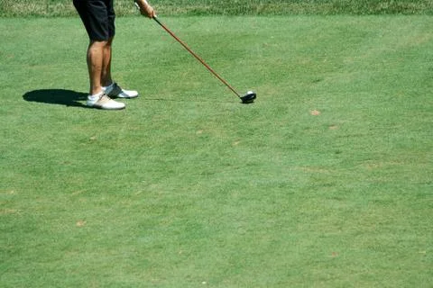 Golfer teeing off with a driver Stock Photos