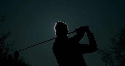 A Golfer tees off with the sun forms a halo around his head. Video stock 103279664